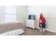 Bedroom featuring wood-look floors, TV on a dresser, and wall mounted coat rack at 14324 Moon Flower Dr, Tampa, FL 33626