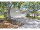 Paver driveway leading to a two-car garage, enhanced by mature trees for a shaded entrance to the residence at 14324 Moon Flower Dr, Tampa, FL 33626