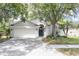 Charming home with a two-car garage and neatly manicured front yard, highlighted by mature trees and shrubbery at 14324 Moon Flower Dr, Tampa, FL 33626