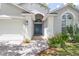 Home featuring a blue front door, a paved walkway, and well-maintained landscaping, set off by a two-car garage at 14324 Moon Flower Dr, Tampa, FL 33626