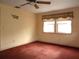 Cozy bedroom with ceiling fan, large window, and plush carpeting at 1747 Douglas Ave, Dunedin, FL 34698