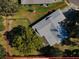 An aerial view showcases a fenced backyard, mature trees, and a partially covered patio at 2640 Westchester N Dr, Clearwater, FL 33761