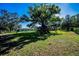 Spacious backyard featuring mature trees, playset, pergola, and fire pit at 2640 Westchester N Dr, Clearwater, FL 33761
