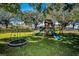 Lawn and play structure in the yard featuring a swing, climbing area, and a double slide at 2640 Westchester N Dr, Clearwater, FL 33761