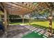 Cozy backyard brick patio under a wooden pergola, perfect for outdoor entertaining at 2640 Westchester N Dr, Clearwater, FL 33761