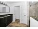 Modern bathroom features granite counters, sleek black cabinetry, and a walk-in shower with marble walls at 2640 Westchester N Dr, Clearwater, FL 33761