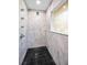 Beautiful bathroom with floor-to-ceiling marble, dark tile floor, and modern shower fixtures at 2640 Westchester N Dr, Clearwater, FL 33761