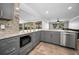 This kitchen features granite counters, stainless appliances, and gray cabinets with backyard views at 2640 Westchester N Dr, Clearwater, FL 33761