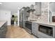 Renovated kitchen offers stainless steel appliances, gray cabinets, granite countertops, and modern fixtures at 2640 Westchester N Dr, Clearwater, FL 33761