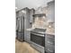 Modern kitchen includes granite countertops, stainless steel appliances, and gray cabinets at 2640 Westchester N Dr, Clearwater, FL 33761