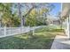 Landscaped backyard with a white picket fence at 35608 Welby Ct, Zephyrhills, FL 33541