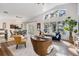 Open-concept living room and dining area with modern furnishings and natural light from large windows at 35608 Welby Ct, Zephyrhills, FL 33541