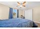 Bedroom with a blue comforter, ceiling fan and sliding door to closet at 4642 Eastwood Ln, Holiday, FL 34690