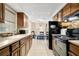 Kitchen with black appliances and wood cabinets, view of dining area at 4642 Eastwood Ln, Holiday, FL 34690