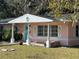 Quaint pink house with white trim and teal columns, showcasing a charming facade at 6035 Grand Blvd, New Port Richey, FL 34652