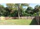 Fenced backyard with grassy area and mature trees at 6041 Dublin Dr, New Port Richey, FL 34653