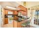 View of kitchen with wood cabinets, granite countertops, and a breakfast bar at 8150 Rose Petal Ct # E, Port Richey, FL 34668