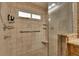 Tiled bathroom featuring a glass door shower, window, and chrome hardware at 9719 Pleasant Run Way, Tampa, FL 33647