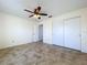 Bedroom with tile floors, ceiling fan, and double door closet at 1029 Fuchsia Dr, Holiday, FL 34691