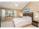 King-size bed in bright bedroom with bay window and ceiling fan at 10494 Saint Tropez Pl # 202, Tampa, FL 33615