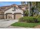 Tan two-story condo with two-car garage, lush landscaping, and a tile accent at 10494 Saint Tropez Pl # 202, Tampa, FL 33615