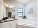 Spa-like bathroom featuring a soaking tub and granite vanity at 11409 Drifting Leaf Dr, Riverview, FL 33579