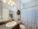 Clean bathroom with striped shower curtain and granite vanity at 11409 Drifting Leaf Dr, Riverview, FL 33579
