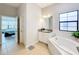 Bathroom with soaking tub, vanity, and a view into the bedroom at 11409 Drifting Leaf Dr, Riverview, FL 33579