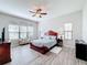 Bright bedroom with wood flooring, large windows and a ceiling fan at 11409 Drifting Leaf Dr, Riverview, FL 33579