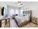 Main bedroom with a plush bed, large windows, and wood-look flooring at 11409 Drifting Leaf Dr, Riverview, FL 33579