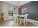 Bright dining room with modern light fixture and seating for six, with large picture window at 12306 Woodlands Cir, Dade City, FL 33525