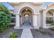 Inviting front entrance with arched entryway, double doors, and manicured landscaping at 12306 Woodlands Cir, Dade City, FL 33525