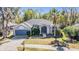 Charming single-story home featuring a lush front yard and attached two car garage at 12306 Woodlands Cir, Dade City, FL 33525