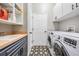 Functional laundry room boasts stylish star-patterned tile floors and new stainless-steel washer and dryer at 12306 Woodlands Cir, Dade City, FL 33525