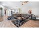Cozy living room boasts a large sectional sofa, modern rug, and wood-look floors at 12306 Woodlands Cir, Dade City, FL 33525