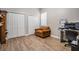 Home office with an orange armchair, desk, two closets and hardwood flooring at 12306 Woodlands Cir, Dade City, FL 33525