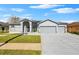 Two-story house with gray exterior, three-car garage, and well-maintained lawn at 13026 Prestwick Dr, Riverview, FL 33579