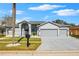 Two-story house with gray exterior, three-car garage, and landscaped front yard at 13026 Prestwick Dr, Riverview, FL 33579