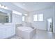 Elegant bathroom with soaking tub, double vanity, and large mirror at 13079 Willow Grove Dr, Riverview, FL 33579