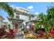 Two-story light blue house with red door and lush tropical landscaping at 151 18Th Ne Ave, St Petersburg, FL 33704