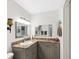 Bathroom vanity with gray cabinets, granite countertop, framed mirrors and decorative lighting at 1901 Lennox E Rd # 1901, Palm Harbor, FL 34683