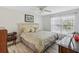 Cozy bedroom with a ceiling fan, large window, and decorative headboard at 1901 Lennox E Rd # 1901, Palm Harbor, FL 34683