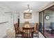 Dining area with an elegant chandelier, seating for four, and sliding glass door to the patio at 1901 Lennox E Rd # 1901, Palm Harbor, FL 34683