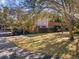 Exterior view of the home with mature trees, carport parking and well manicured lawn at 1901 Lennox E Rd # 1901, Palm Harbor, FL 34683