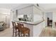 Breakfast bar with seating provides an open view into the kitchen with white appliances at 1901 Lennox E Rd # 1901, Palm Harbor, FL 34683
