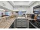 Kitchen featuring stainless steel appliances, gray cabinets, and a breakfast bar overlooking living area at 1901 Lennox E Rd # 1901, Palm Harbor, FL 34683