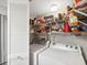 Functional laundry area with stacked machines and shelving for storage of detergent and other cleaning supplies at 1901 Lennox E Rd # 1901, Palm Harbor, FL 34683