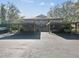 Rear view of townhome featuring carport parking for multiple vehicles, ample parking space, and exterior staircase at 1901 Lennox E Rd # 1901, Palm Harbor, FL 34683