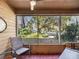 Relaxing screened porch showcasing views of a lush, green landscape and mature trees at 1901 Lennox E Rd # 1901, Palm Harbor, FL 34683