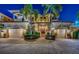 Elegant waterfront home at night with palm trees, double garage, and a grand entrance at 308 Harbor Dr, Indian Rocks Beach, FL 33785